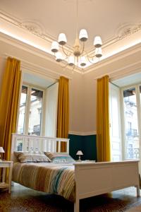 卡塔尼亚B&B Umberto 134的一间卧室配有一张黄色窗帘和吊灯的床。