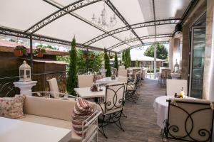 阿赫洛伊семеен хотел Прованс Ахелой的餐厅设有白色的桌椅和玻璃天花板