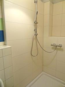 LoissinFerienhaus Loissin的浴室内带软管的淋浴