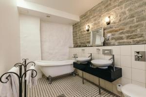 塔林梅查特斯家庭酒店的一间带水槽、浴缸和卫生间的浴室