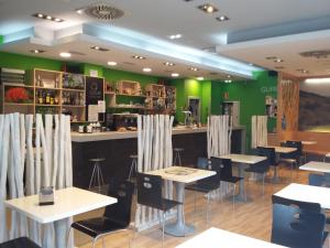 贝亚赛恩Hotel Beasain的餐厅设有桌椅和绿色的墙壁