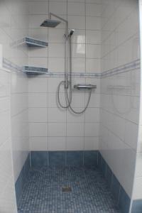 旺格兰Landhaus-Altebrücke的浴室铺有白色瓷砖,设有淋浴。