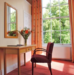 都柏林墨翰普顿联排别墅酒店的窗户客房内的一张桌子和一把椅子