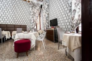 威尼斯凯诺比利考勒讷酒店的一间带桌椅和电视的餐厅