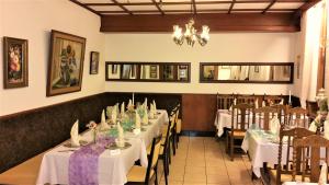 施瓦尔姆塔尔拉特酒店的一间配备有白色桌椅和吊灯的餐厅