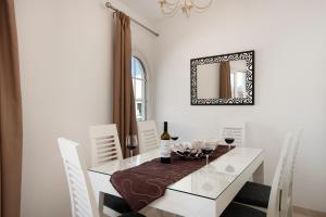 卡门港Apartment Old Town的一间设有白色桌子和镜子的用餐室