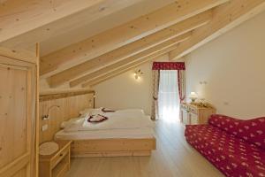 坎皮泰洛迪法萨Cesa Melester的一间卧室配有一张床和一张红色的沙发