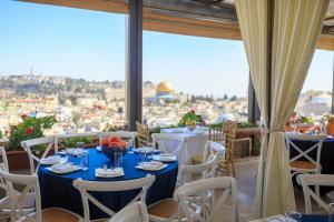 耶路撒冷哈希米酒店 的一间设有桌椅的餐厅,享有城市美景