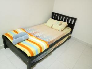 Bandar Puncak Alam庞克阿兰阿尔曼达公寓的一张带彩色毯子和枕头的小床