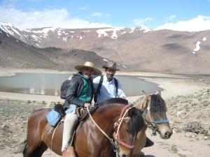 San Esteban圣埃斯特万酒店的两个在湖前骑马的人