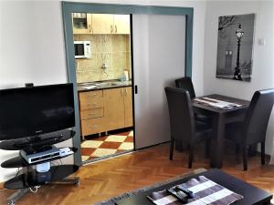 波德戈里察中心点公寓酒店的客厅配有电视和桌椅