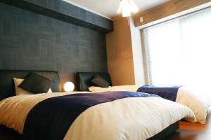 广岛广岛袋町千鸟公寓的一间卧室设有两张床和大窗户