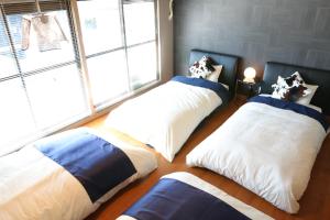 广岛广岛袋町千鸟公寓的带大窗户的客房内的三张床