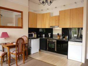 切尔滕纳姆帕拉贡服务式公寓的厨房配有黑白电器和桌子
