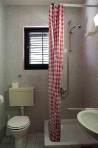 韦伯斯卡Guest House Alek的浴室设有红色和白色的窗帘