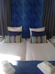 马尔森Bed & Breakfast Geesberge的一间卧室设有两张带蓝色墙壁的床