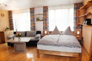 里姆斯廷格Chiemsee Comfort-Bungalow mit Garten的一间卧室配有一张床、一张沙发和一张桌子