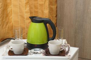 阿波罗尼亚Margarita Karidi的一张带两个杯子的桌子上的绿色咖啡壶