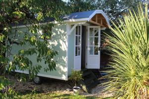 OtheryLittle England Retreats - Cottage, Yurt and Shepherd Huts的花园里的一个小绿色房子