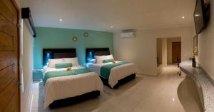 Ciudad ConstituciónHotel Mumai的一间卧室配有两张绿色和白色的床
