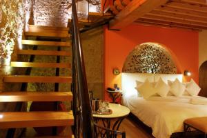 克雷塔罗Casona de la Republica Hotel Boutique & SPA的一间卧室设有一张床和一个楼梯