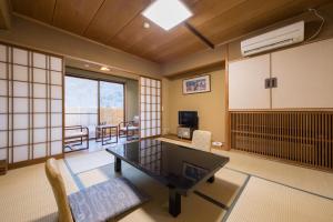 松本Hotel Umenoyu的一间客房内配有桌椅的房间