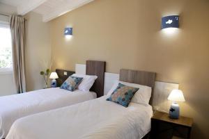 卡利亚里Avion B&B的两张床位于带两盏挂在墙上的灯的房间