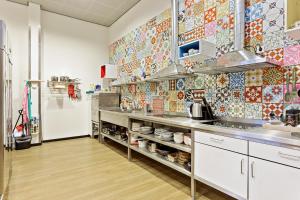 阿姆斯特丹Hostelle - women only hostel Amsterdam的厨房的墙上铺有彩色瓷砖