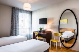 旺夫巴黎旺夫爱达格公寓式酒店 - 波特德夏特林的酒店客房,设有两张床和镜子
