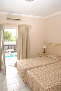 居姆贝特热带海滩酒店的一间带大床的卧室和一个阳台