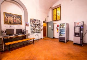 佛罗伦萨圣莫纳卡旅舍的大型客房配有书桌和冰箱。