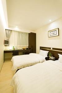 香港Pop Inn Mong Kok的酒店客房配有两张床和一张书桌