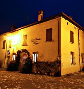 Bagnara di Romagna洛坎达迪巴尼雅拉酒店的白色的建筑,晚上有标志
