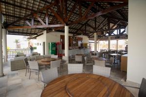 阿奎拉兹Beach Place Resort Bangalo 12的配有木桌和桌椅的餐厅