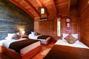 普孔阿尔迪诺卡纳波萨达精品旅馆的一间带两张床铺的卧室,位于带木墙的房间内