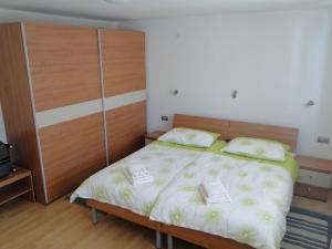 莫斯特纳索契Apartma Jezero的一间卧室配有一张大床和木制床头板