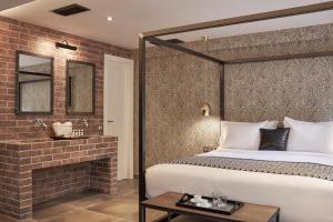 雅典米康海峡18号酒店的一间卧室设有一张床和砖墙