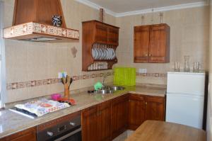 埃尔博斯克ÁTICO CAHI的厨房配有木制橱柜和白色冰箱。
