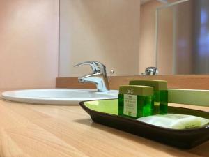 Chambon-sur-Dolore拉格莱德酒店的浴室的柜台设有水槽和镜子
