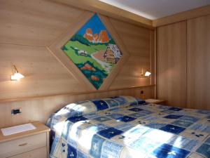 坎皮泰洛迪法萨Appartamenti Majon Sotroi的一间设有一张壁画床的房间