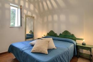 莱乌卡Scogliera del Gabbiano的一间卧室配有一张带蓝色床单和镜子的床