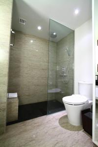 万隆万隆森萨酒店的一间带卫生间和玻璃淋浴间的浴室