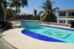 圣安特罗Condominio Punta Bolivar的一座位于房子前方的蓝色瓷砖游泳池