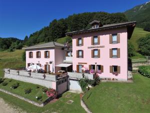 阿维奥Albergo Alpino da Tullio的山丘上粉红色房子的空中景色