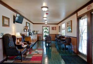 尤里卡斯普林斯Regency Inn Eureka Springs的一间设有椅子、桌子和电视的等候室