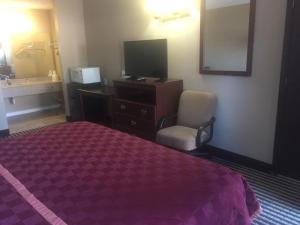 尤里卡尤里卡美国最佳价值套房酒店的酒店客房带一张床、一台电视和一把椅子