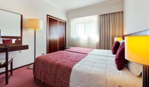 法蒂玛卢克希沐恩迪酒店的酒店客房设有一张大床和一张书桌。
