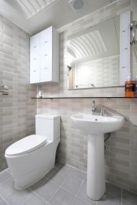 水原市SB之楼旅舍的白色的浴室设有卫生间和水槽。