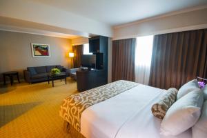 马那瓜马那瓜皇冠广场酒店的酒店客房设有一张大床和一间客厅。