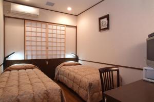 横滨横滨港未来万叶俱乐部酒店的一间卧室设有两张床、一张桌子和一个窗口